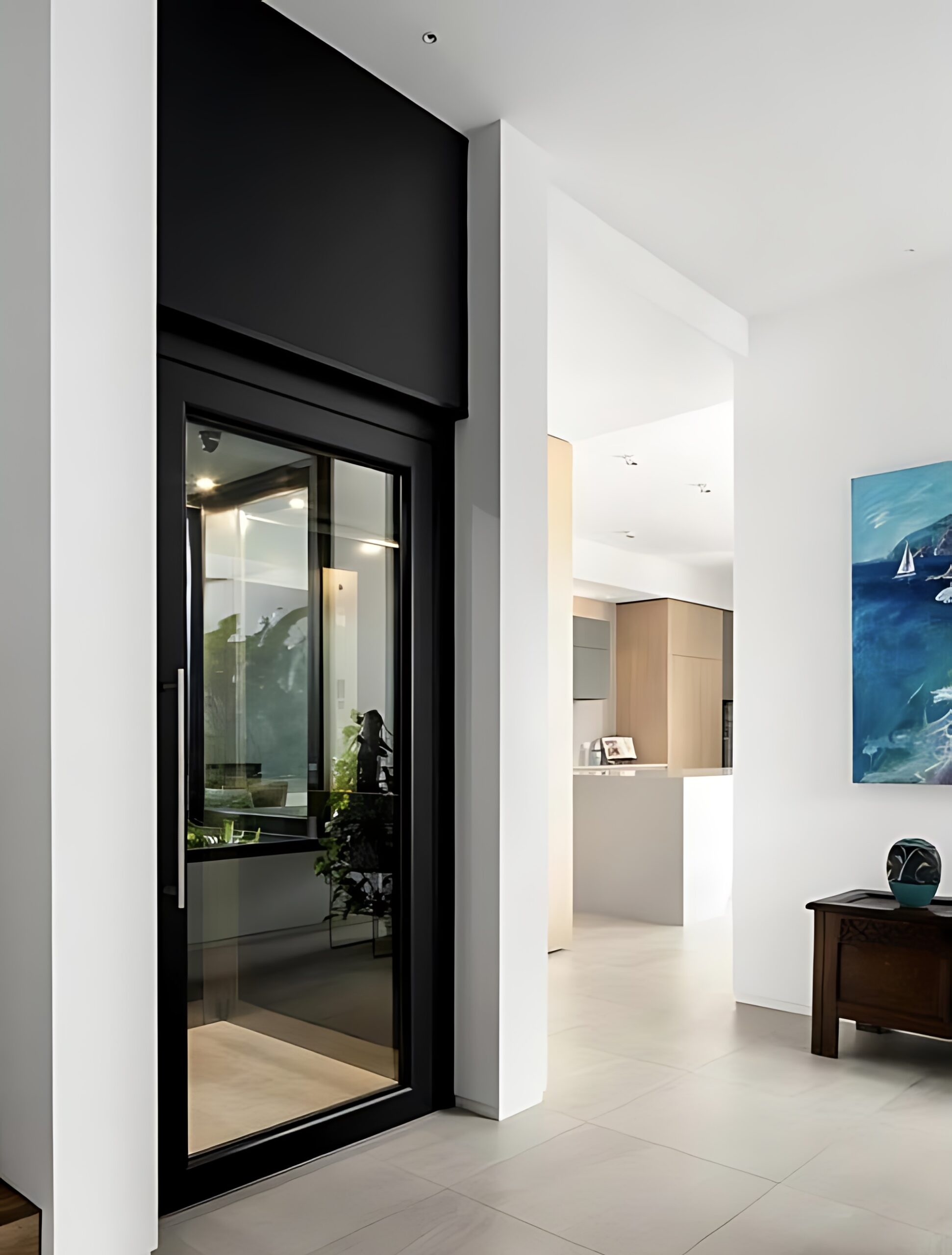 Elevator Boutique glass home elevator with a glass swing door beside a floating staircase