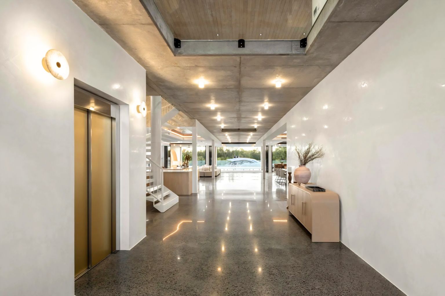 Elevator Boutique automatic gold sliding door home elevator in a modern concrete hallway