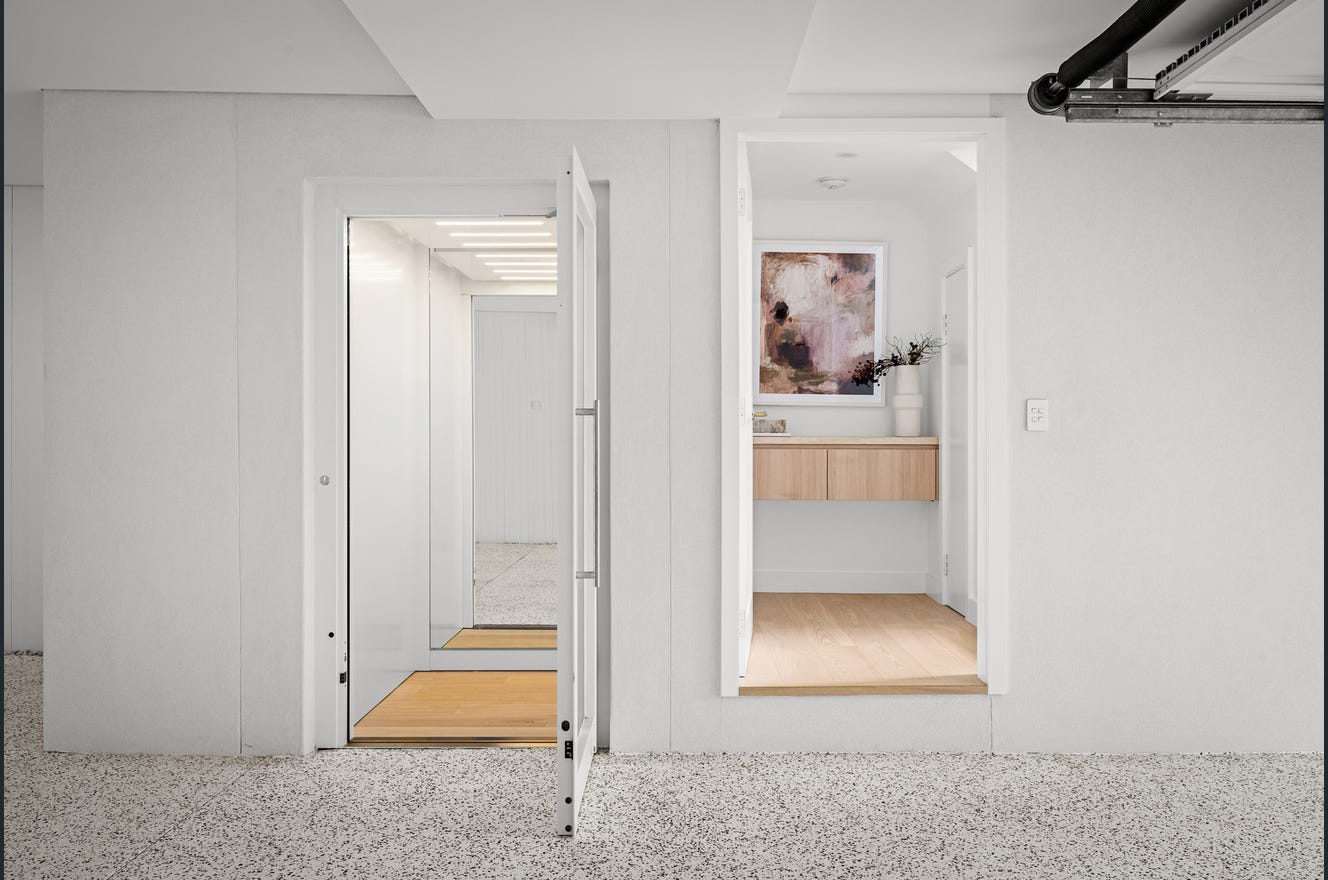 Elevator Boutique home elevator with a white swing door open to a full-sized cabin