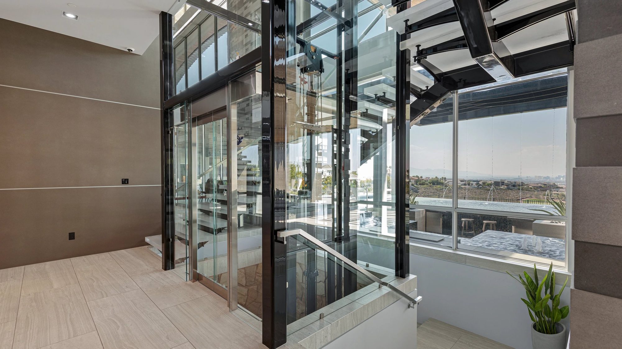 Glass Elevator Boutique home elevator beside a floating staircase